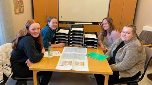 Fire jenter frå elevrådsstyret 2022/2023 som sit ved eit bord. Foto: Stryn vgs