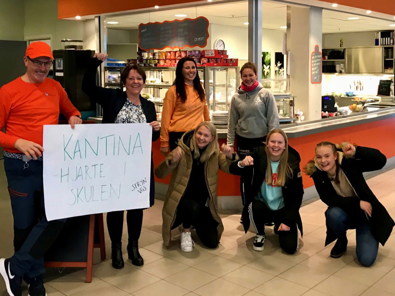Bilde av elevar og tilsette med plakaten: Kantina - hjarte i skulen. Foto: Leif Magne Grastveit, Matvalget