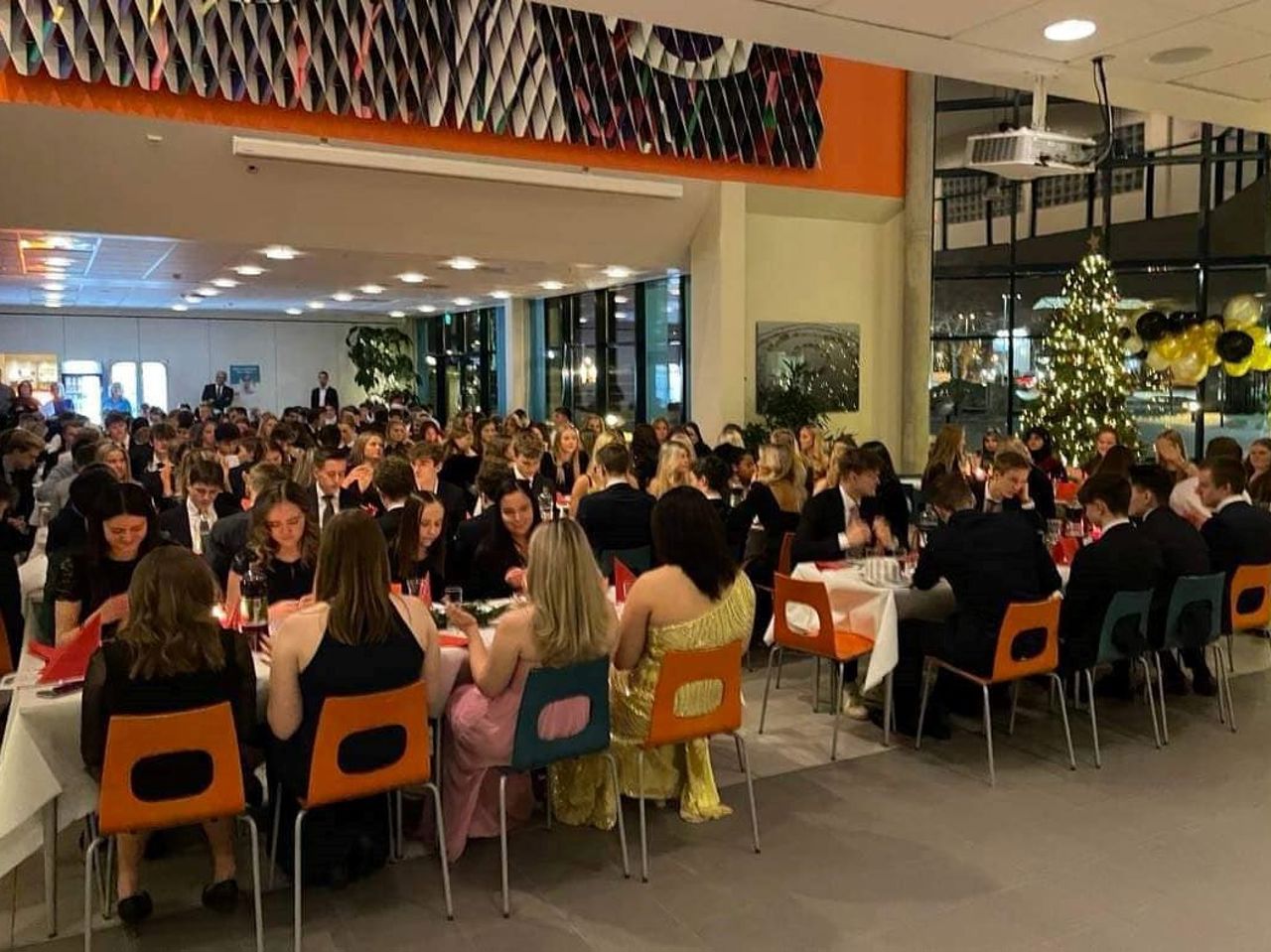 Mange festkledde elevar som sit til bords i kantina. Foto: Maria Storevik/Stryn vgs