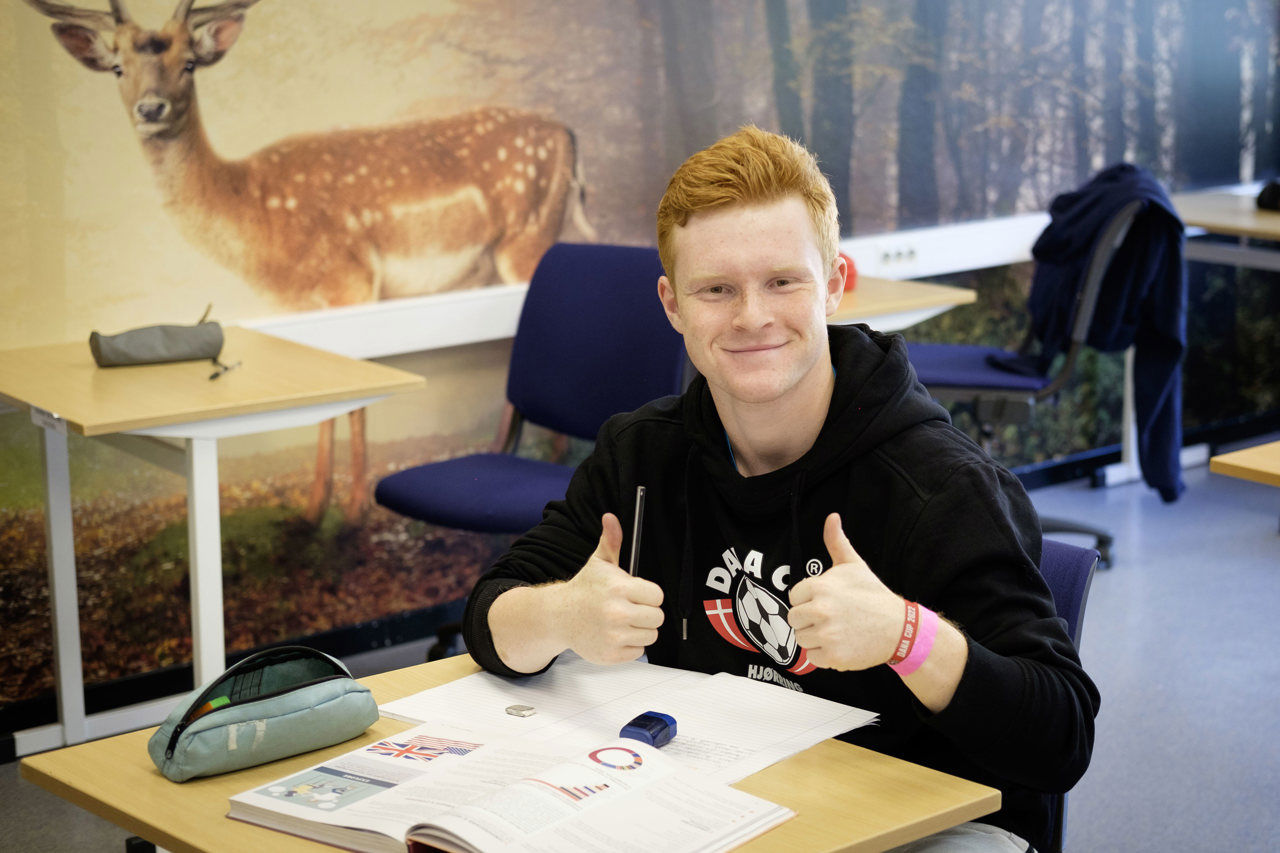 Elev i klasserommet med tommel opp. Foto: Reed fotoet