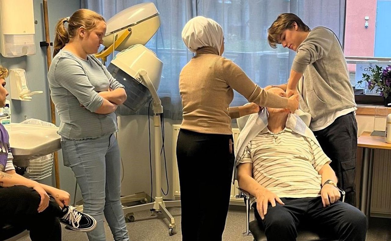 Elevar vaskar håret til bebuar på omsorgssenteret.  Foto: Stryn vgs