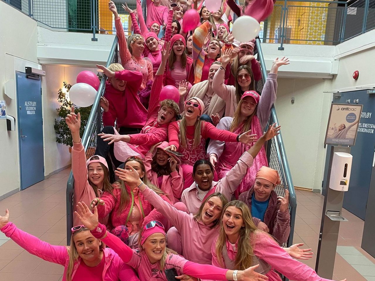 Mange elevar har kledd seg ut i rosa og sit i ei trapp. Foto: Stryn vgs