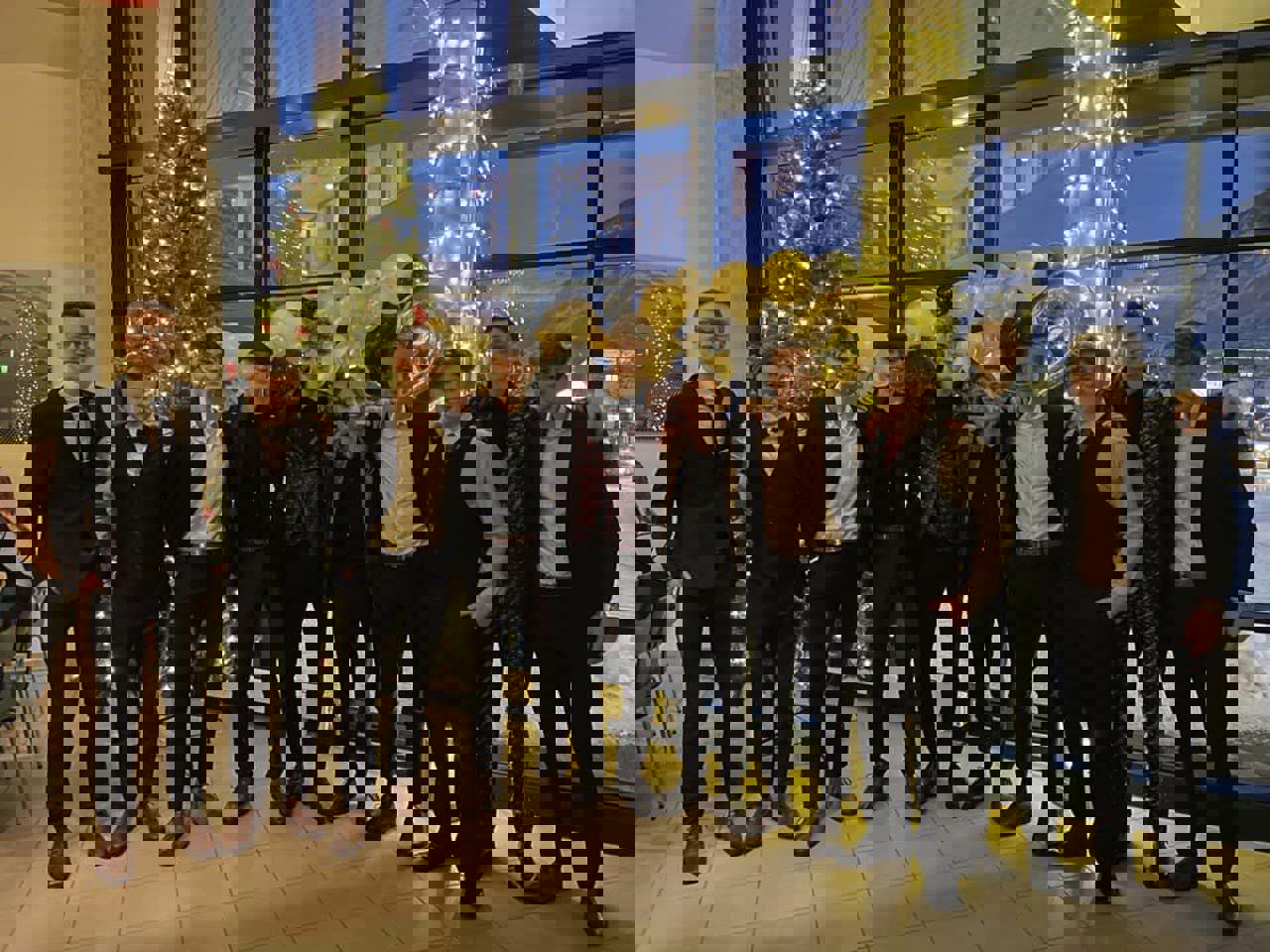 Ti festkledde gutar framfor juletreet. Foto: Stryn vgs