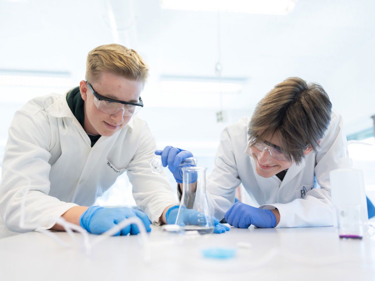 To gutar som held på med kjemieksperiment på lab. Foto: Reed foto