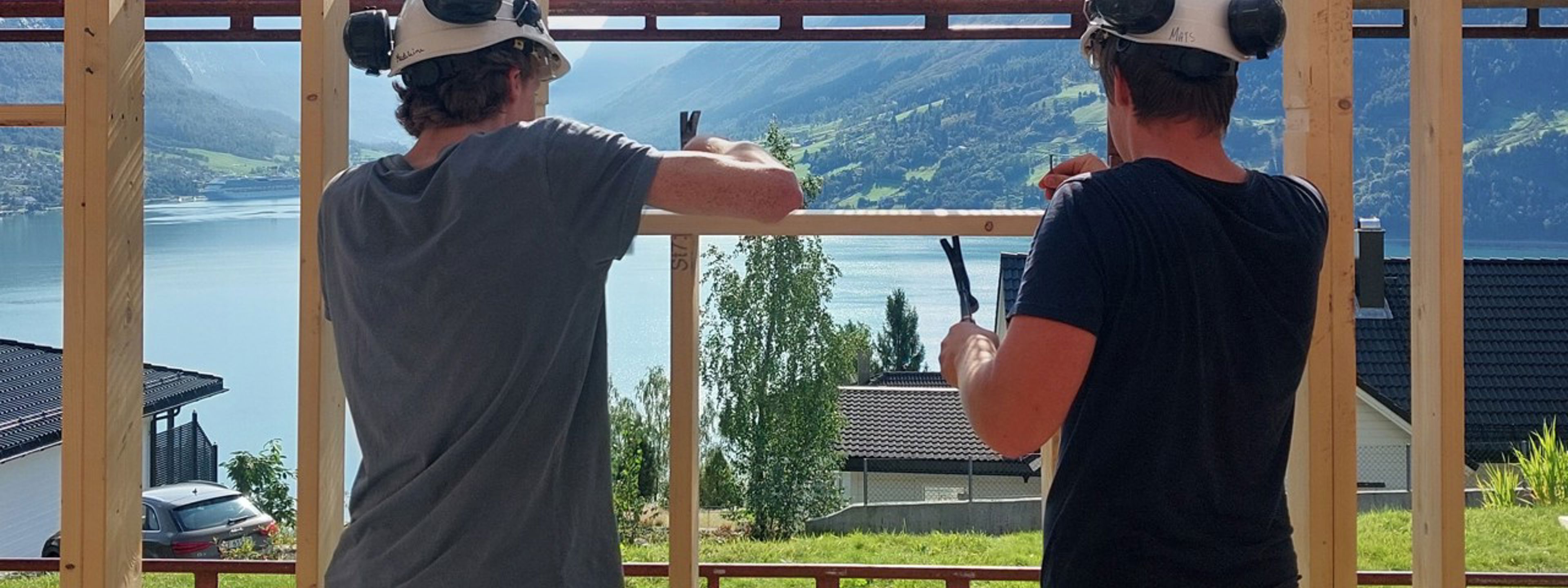 To byggfagelevar i arbeid ute i sola. Foto: Stryn vgs