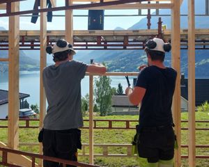 To byggfagelevar i arbeid ute i sola. Foto: Stryn vgs