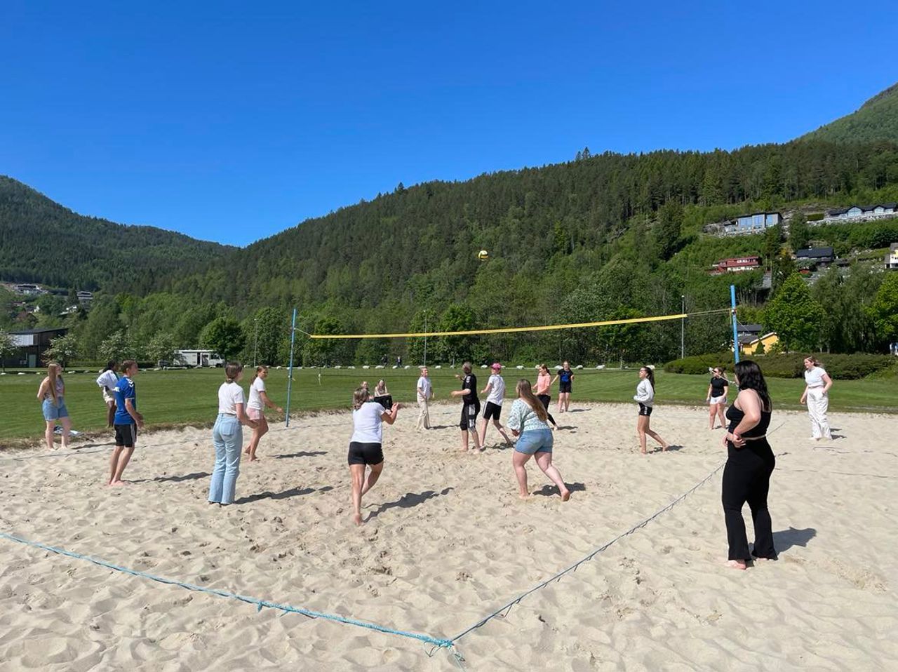 Elevar som spelar beach-volleyball