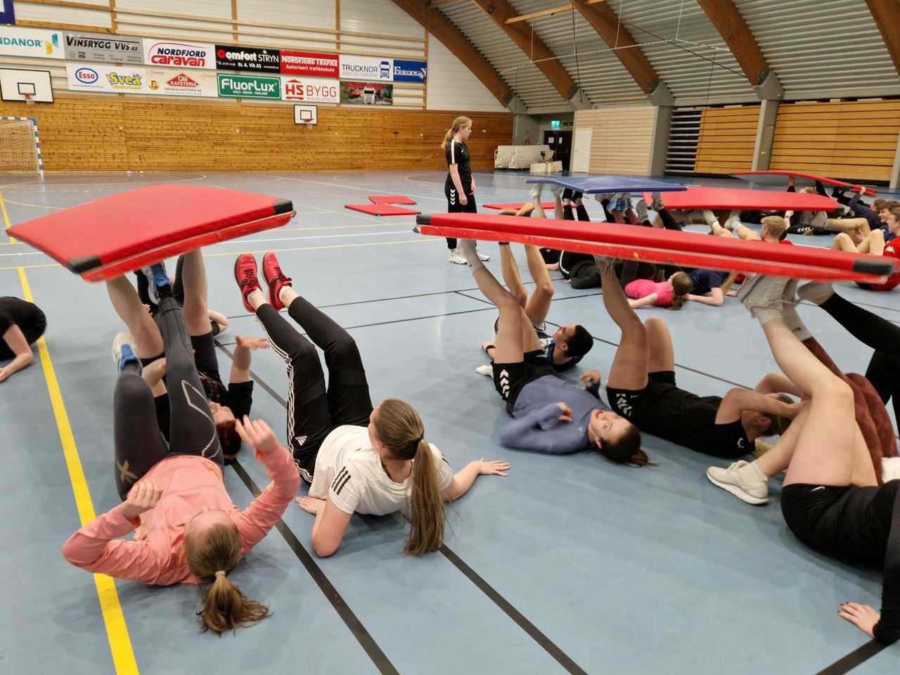 Elevar som balanserer turnmatter med føtene i hallen. Foto: Stryn vgs