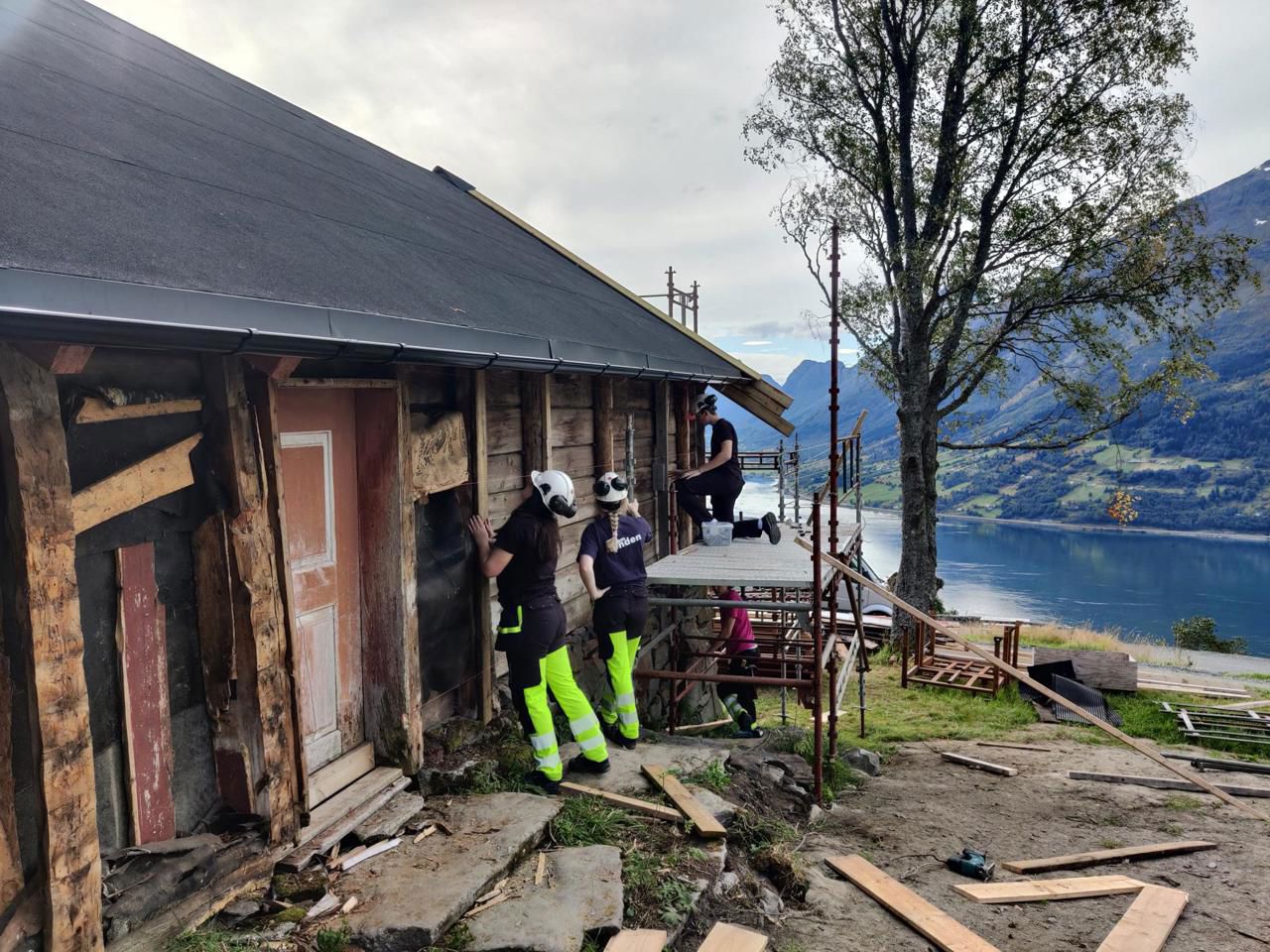 Tre elevar som restaurerer ein gammal bygning. Foto: Stryn vgs